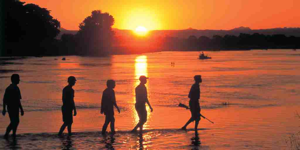 THE BUSHCAMP COMPANY   sunset walk across the Kapamba river