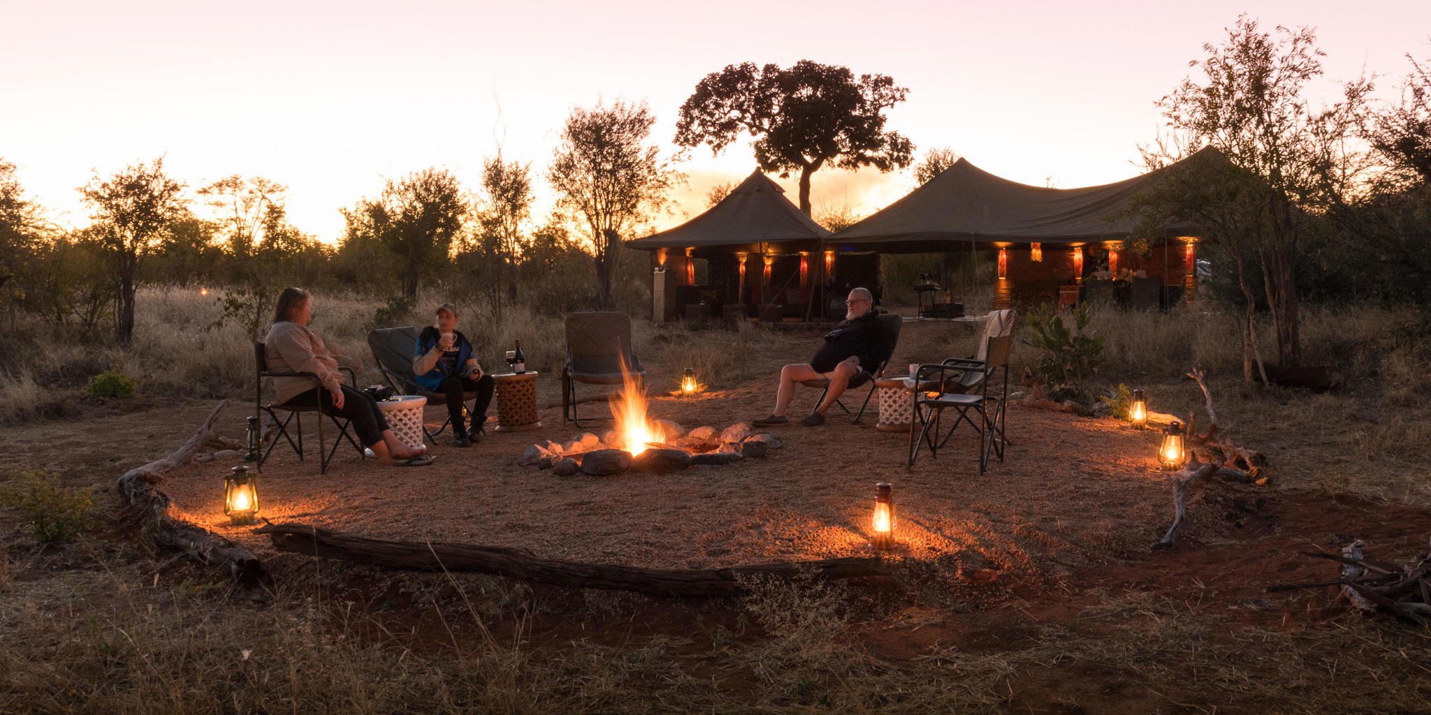 A group of people sitting around a fire in a outside boma. Listening peacefully to the evening sounds of nature complemented by the smells of smoke and bushveld. 