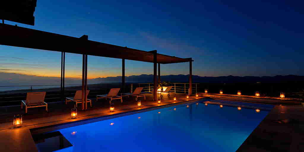 the villa pool lit up at night