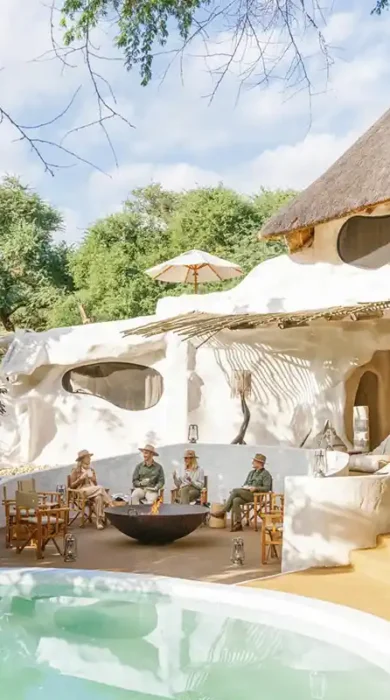 Guests sit and socialise near the pool area at Chongwe House - a private home in the Lower Zambezi National Park.