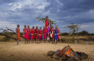 Members of the Maasai tribe around a fire, Mara, Kenya - Yellow Zebra Safaris