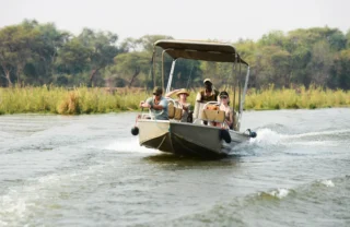 A boat motoring down the Zambezi, Lower Zambezi National Park, Zambia - Yellow Zebra Safaris