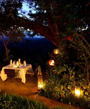 Secluded table lit by candles prepared for a private dinner, Gibb's Farm, Tanzania - Yellow Zebra Safari