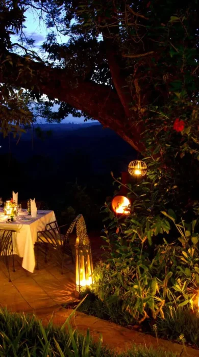 Secluded table lit by candles prepared for a private dinner, Gibb's Farm, Tanzania - Yellow Zebra Safari