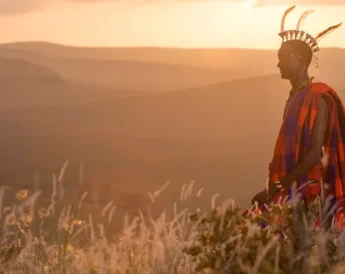 A man in traditional Maasai dress at sunset, Sirikoi, Kenya - Yellow Zebra Safaris