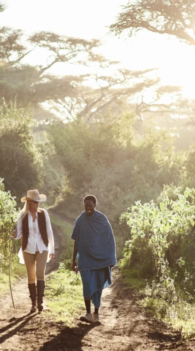 A guest and a guide walk in lush greenery, Serengeti, Tanzania - Yellow Zebra Safari
