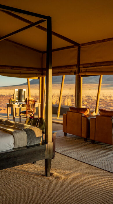 An interior view of the four poster bed which looks out onto the dunes, Wolwedans Plains Camp, Namibia - Yellow Zebra Safaris