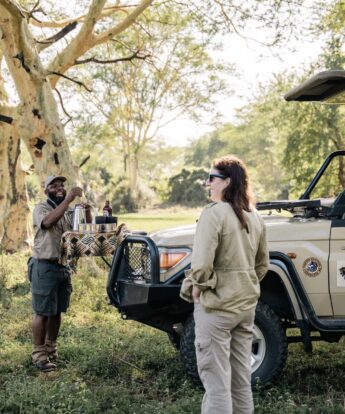 Guests and guide stand around the safari vehicle, Muzimu Lodge, Gorongosa, Mozambique - Yellow Zebra Safaris