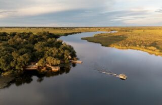 An aerial shot of a boat's river crossing, Camp Xugana Island Lodge, Okavango Delta, Botswana - Yellow Zebra Safaris