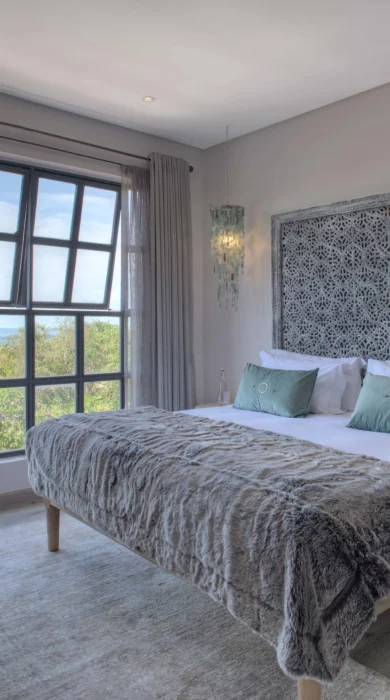 A double bed with grey bedding at Latitude 0 Degrees, Kampala, Uganda - Yellow Zebra Safaris