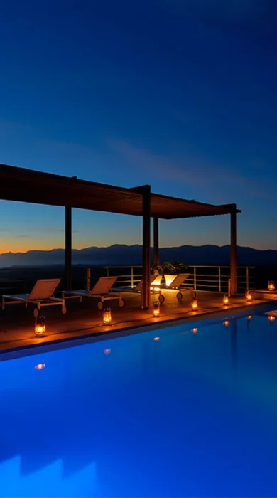 the villa pool lit up at night